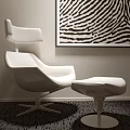 Modern White Lounge Chair With Matching Ottoman And Zebra Print Wall Art On Dark Carpet