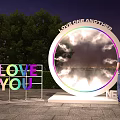 Outdoor Night Scene With Circular Love One Another Installation And Love You Sign