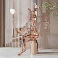 Transparent Rabbit Sculpture Holding Balloon On Gold Base In Modern Interior With Plants