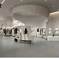 Modern Clothing Store Interior Design With White Curved Structures Clothing Racks And Hanging Apparel