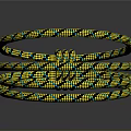 Yellow And Black Patterned Braided Rope Coiled On Reflective Surface