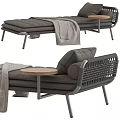 Comfortable Gray Ottoman With Woven Backrest Cushions Wooden Small Round Table And Draped Blanket