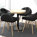 Modern Round Dining Table With Black Chairs And Wooden Legs On Gray Rug