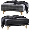 Gray Plaid Fabric And Black Leather Ottoman With Wooden Legs And Draped Black Blanket