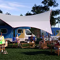 Camping Site With Camper Van White Canopy Green Grass And Outdoor Relaxing Area