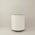 White Cylindrical Kitchen Island With Dark Top And Vertical Stripes In Light Room Corner