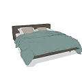 Double Bed With Dark Headboard Green Quilt And Light Brown Pillows