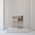 Transparent Leisure Chair with Gray Cushion on White Platform Against Light Colored Wall