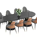 Elegant Modern Dining Table Set with Oval Black Top Gray and Orange Chairs Plant Centerpiece
