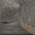 Stone Stairs In Tunnel Like Structure With Stone Walls And Yellow Railings