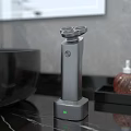 Sleek Electric Shaver On Charging Base With Green Indicator On Bathroom Marble Countertop