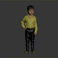 Young Boy In Yellow Shirt Dark Pants And Green Shoes Standing Against Gray Background