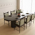 Black Round Dining Table with Six Striped Chairs and Flower Vase on Light Wooden Floor