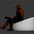 Man Playing Red Electric Guitar On Bean Bag Chair With Gray Amplifier