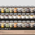 Organized Spice Bottles On Black Rack With Labels For Kitchen Countertop