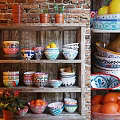 Colorful Ceramic Dinnerware Set With Bowls Plates On Wooden Shelf And Terracotta Pots Oranges