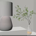 Modern Table Lamp with White Lampshade and Dark Base on Light Tabletop with Green Plant