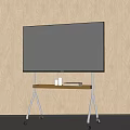 Black TV on Metal Stand with Wooden Top and Wheels Against Light Wooden Wall