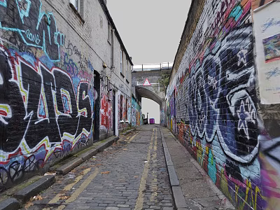 Vibrant Commercial Street Featuring Graffiti Covered Buildings Cobblestone Path and Distant Archway 3d model