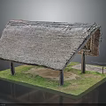 Traditional Thatched Roof Building With Wooden Pillars And Grass Ground