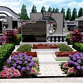 Cemetery Scene With Visitors Taking Photos Walking Path Tombstones Red Flowers And Green Trees