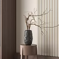 Textured Black Vase With Dried Branches On Wooden Stool Against Vertical Striped Wall