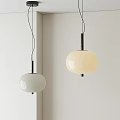 Modern Pendant Lights With White And Cream Round Shades And Black Stems On Wall