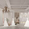 Elegant Bridal Shop Interior With White Wedding Dresses Mannequins Chandelier And White Curtains