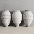 Three White Textured Ceramic Vases Decorative Ornament Set Against Grey Wall On Light Wooden Surface