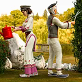 Two People In Traditional Costumes Watering And Trimming Plants In Garden