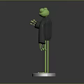 Green Frog Sculpture with Black Clothing Red Eyes and Thumbs Up Gesture on Silver Base