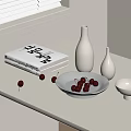 White Ceramic Vessels Including Bowls And Vases On Table With Books And Cherries