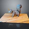 Gray Squirrel Figurine With Unicorn Horn And Fluffy Tail On Wooden Board