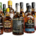 Assorted Liquor Bottles And Glasses Display With Colorful Labels And Unique Shapes