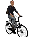 Man In Dark Shirt And Jeans Riding Black Bicycle With Backpack