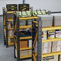 Industrial Metal Storage Racks In Warehouse With Organized Boxes Cans And Forklift