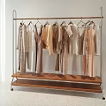 Minimalist Neutral Colored Clothes on Metal Frame Clothing Rack With Wooden Shelf in Bright Room