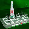 Heineken Silver Bottle With Glasses On Lit Tray And Green Background