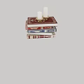 Stack of Books with Red Cover and Gold Candle Holder Featuring White Candles