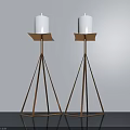 Two Modern Candle Lamps With White Candles And Golden Triangular Stands On Dark Tabletop