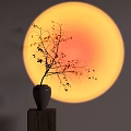 Decorative Vase With Twig On Wooden Platform Against Round Orange Yellow Sunset