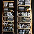 Multi Tiered Wooden Shelf Unit With Potted Plants Baskets Glass Bottles And Decorative Items