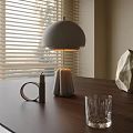 Modern Table Lamp with Dome Shade on Wooden Table and Decorative Items Near Window Blinds