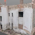Abandoned Ruined Building With White Walls Red Chimneys And Broken Windows