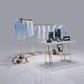 Retail Display Shelving with Hanging Light Blue Shirts Tablet Shoes Plants and Logo on Table