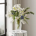 Clear Glass Vase With White Lilies Blue Tulips And Green Leaves On Wooden Table
