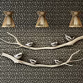 Three Gold Chandeliers Hanging On Textured Dark Wall With Silver Bird Decorations On Branches
