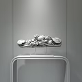 Decorative Ornament Set with Intricate Carved Patterns on Black Metal Stand Against Textured Wall