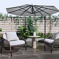 Wicker Outdoor Sofa Set With Umbrella Plants And Side Table On Slate Floor