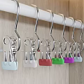 Metal Hooks Hanging On White Rod With Colored Balls Against Wooden Background